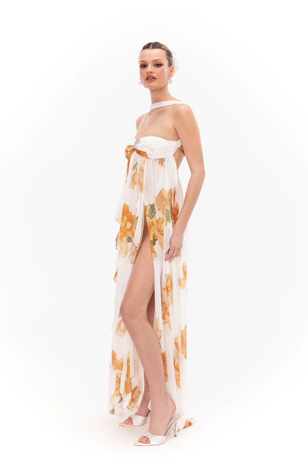 Woman wearing a floral dress with a high slit on a white background
