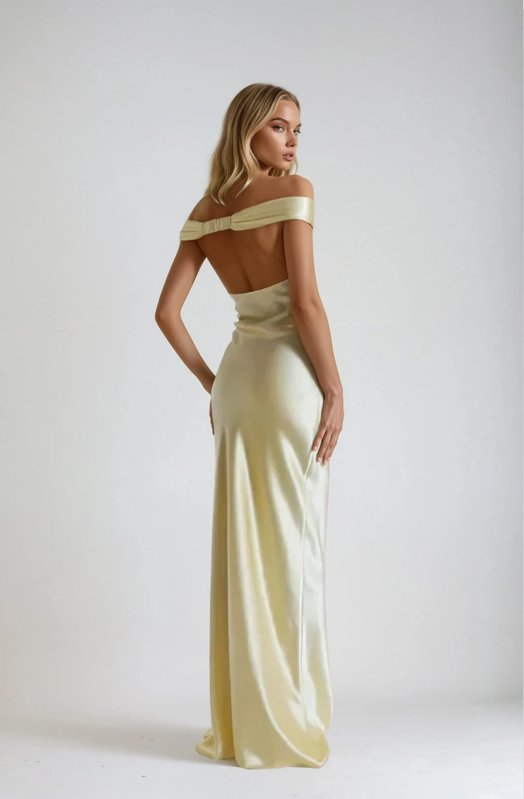 Woman wearing a light yellow off-shoulder gown against a white background