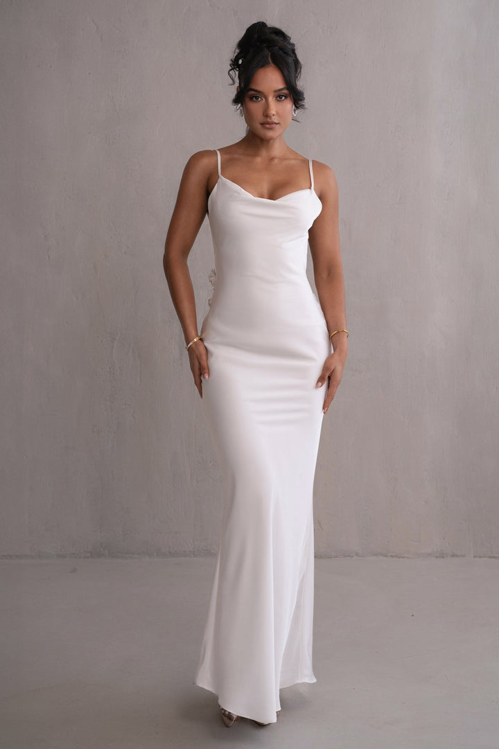 Woman wearing a white dress against a plain background