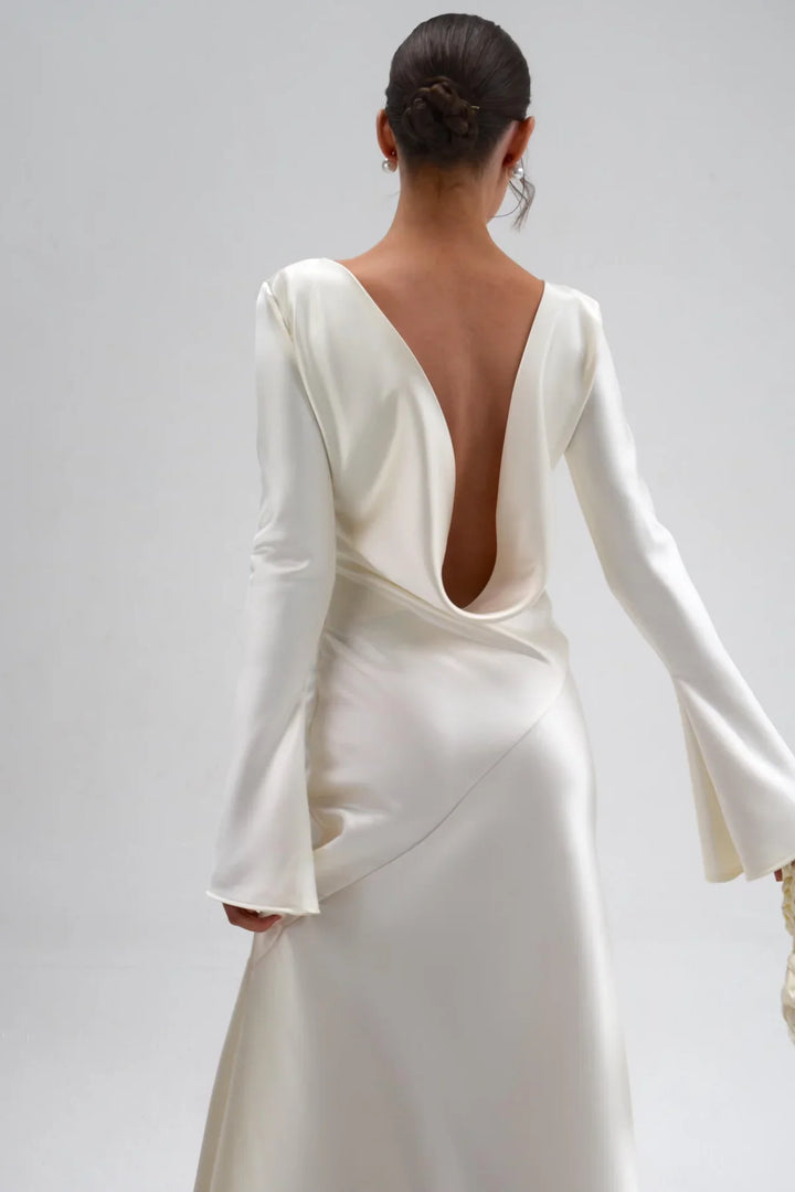 White wedding dress with long sleeves on a plain background
