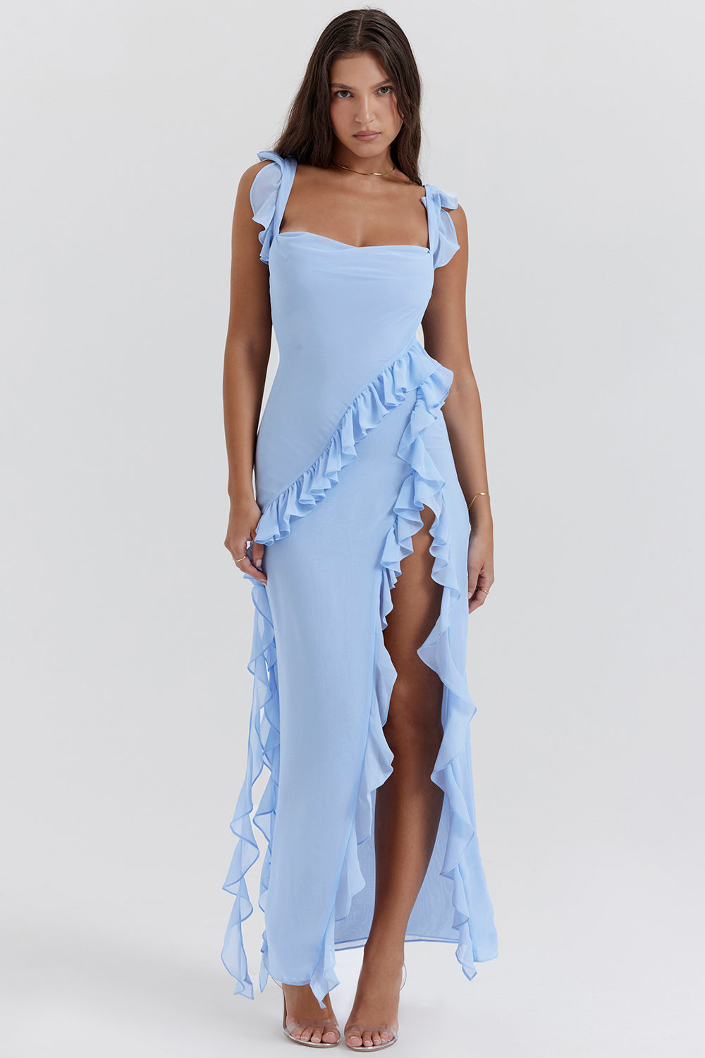 Woman wearing a light blue dress with ruffled details on a white background