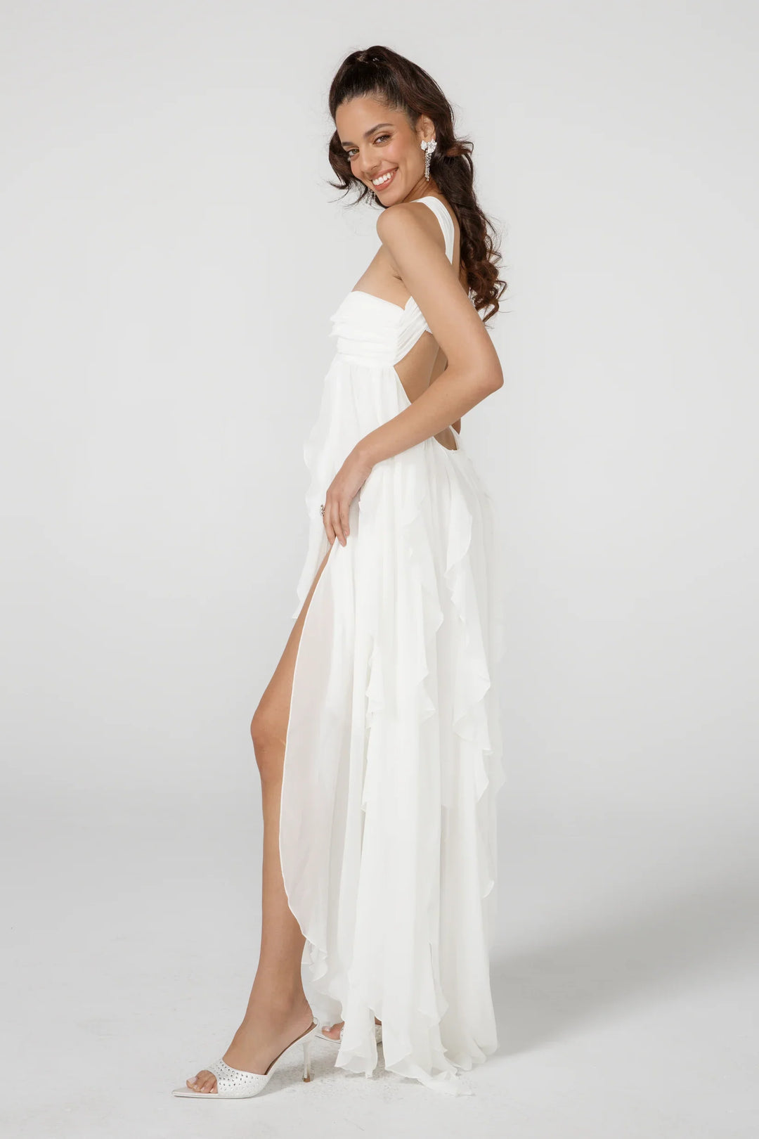 Woman wearing a white dress with a slit on a white background