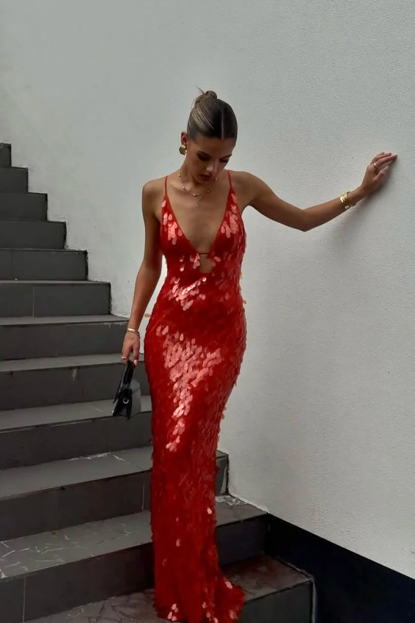 Woman in a red sequin dress standing on a staircase.