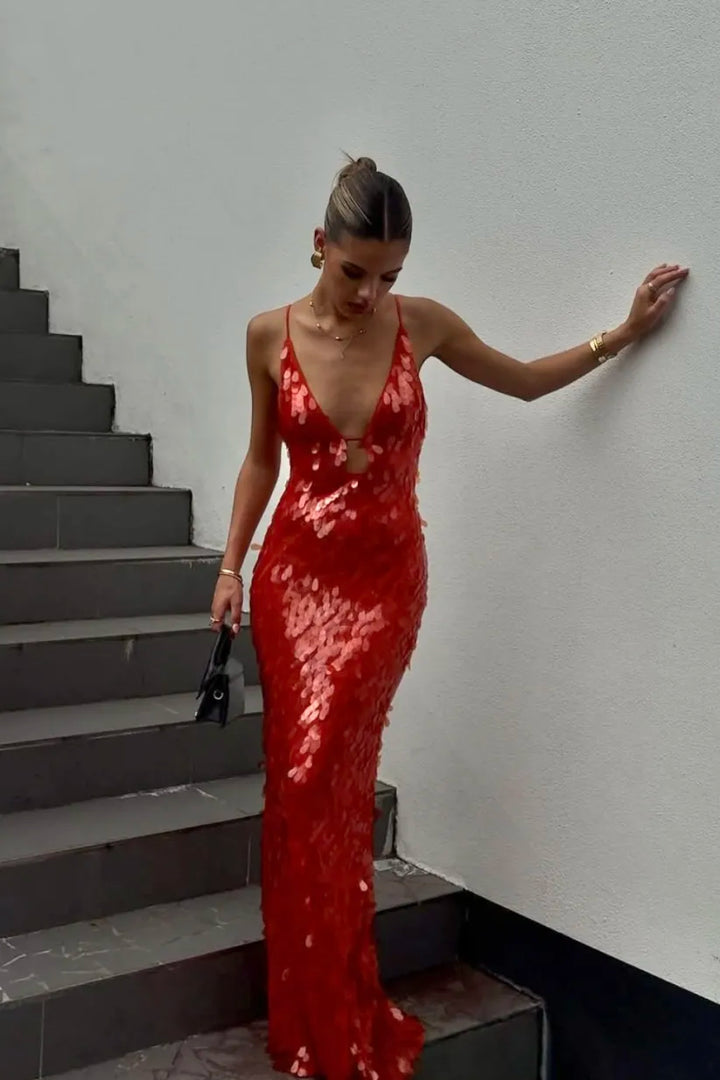 Woman in a red sequin dress standing on a staircase.