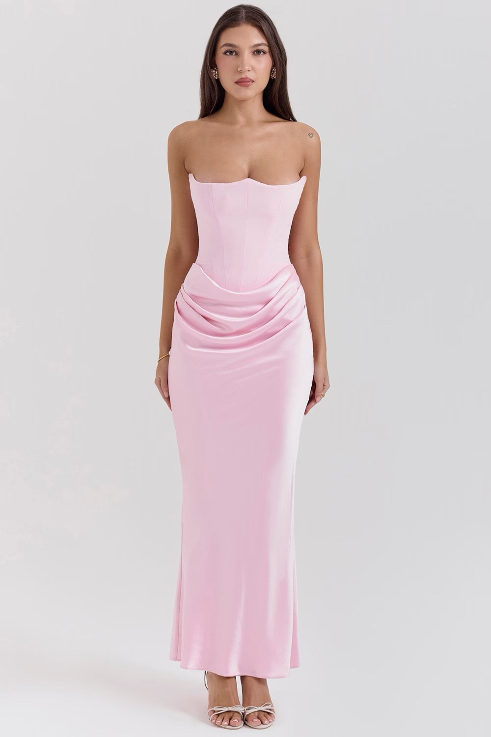 Woman wearing a pink strapless gown on a white background