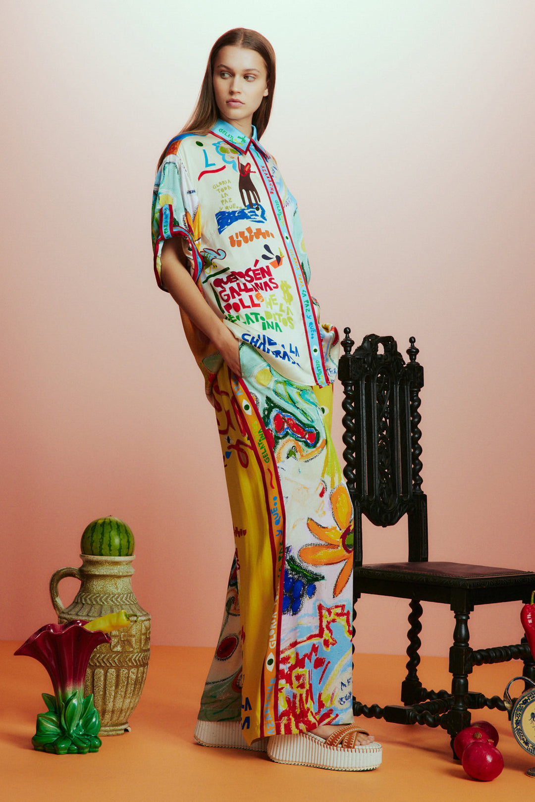 Woman wearing a colorful dress with abstract patterns in a studio setting.