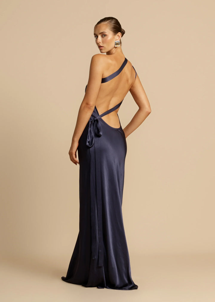 Navy blue evening gown with open back on a beige background