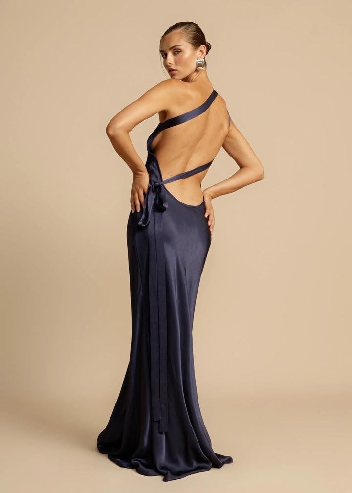Navy blue evening gown with open back on a beige background