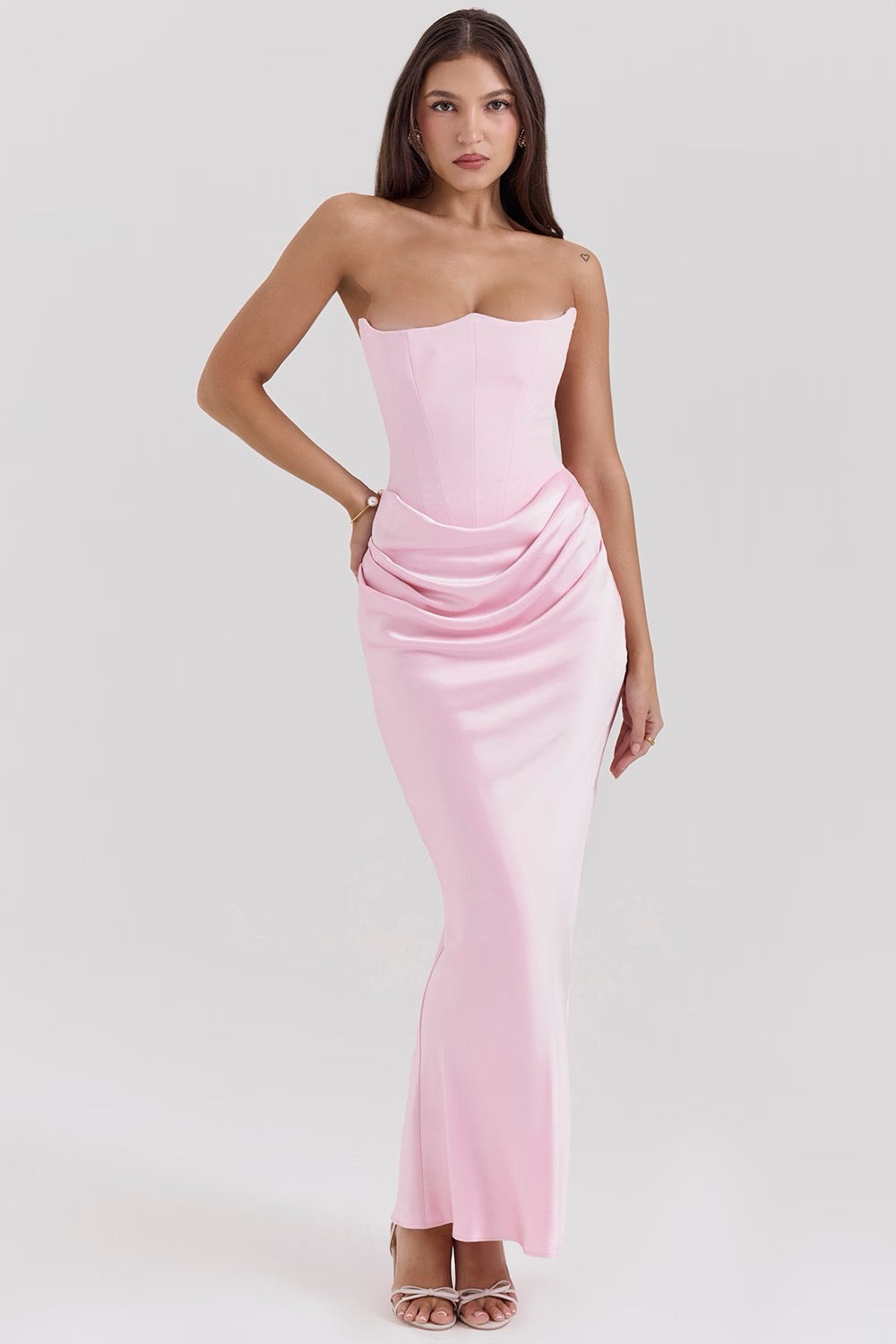 Woman wearing a strapless pink dress on a white background