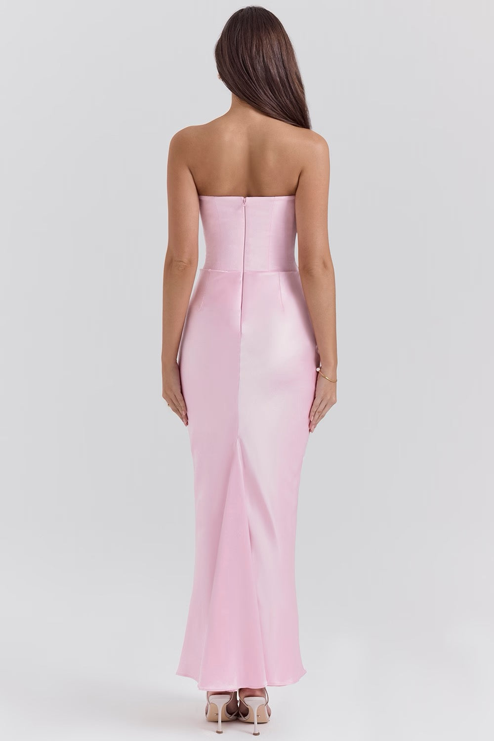 Woman wearing a strapless pink gown on a white background