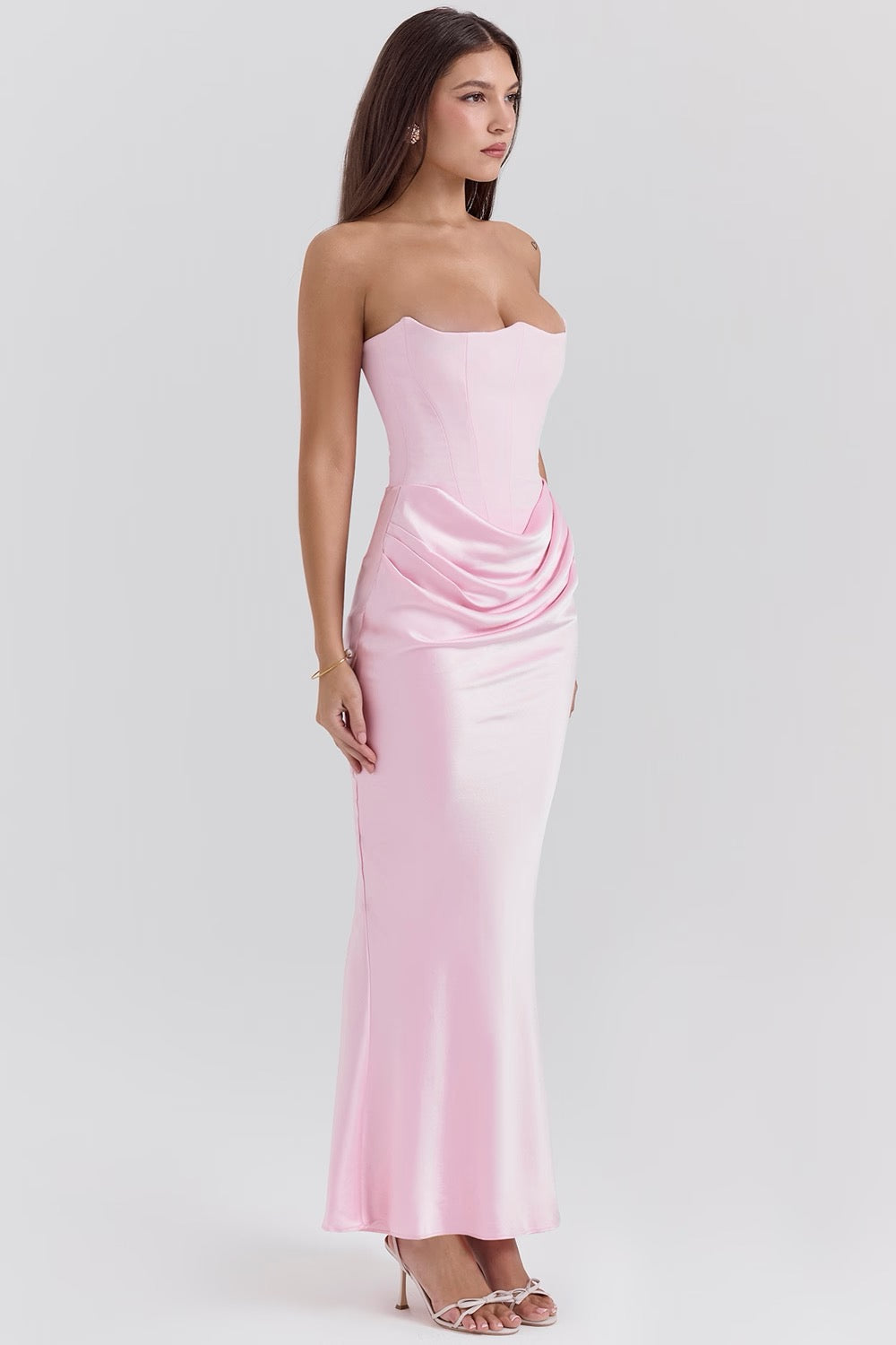Woman wearing a strapless pink dress on a white background
