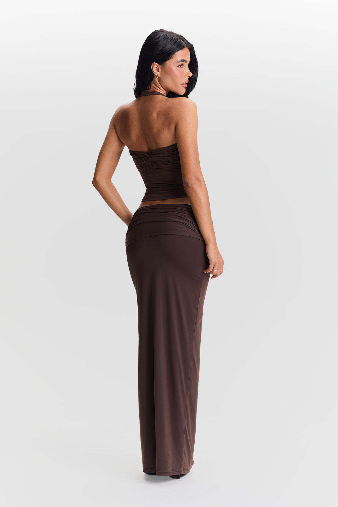 Woman wearing a brown strapless dress on a white background