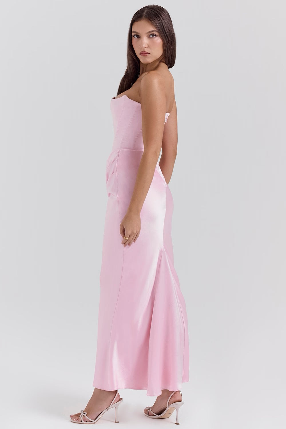 Woman wearing a pink strapless dress on a white background