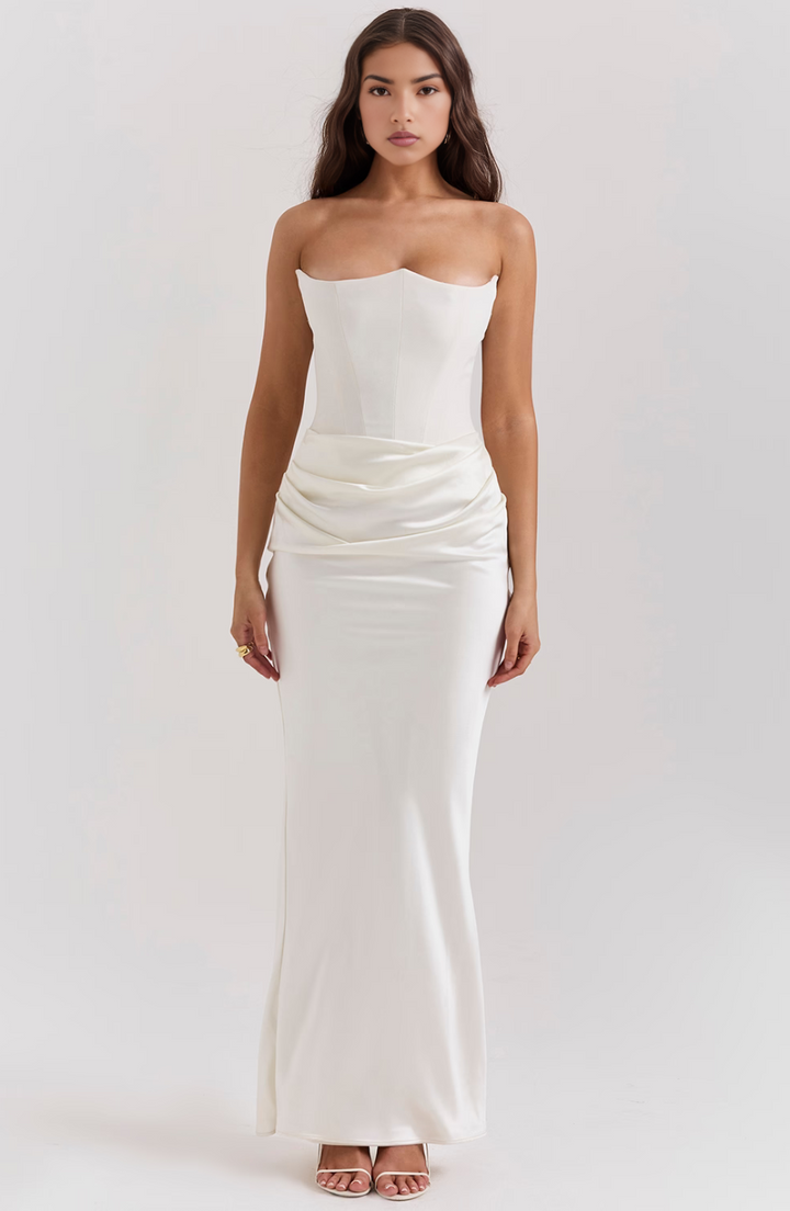 Woman wearing a white strapless gown on a plain background