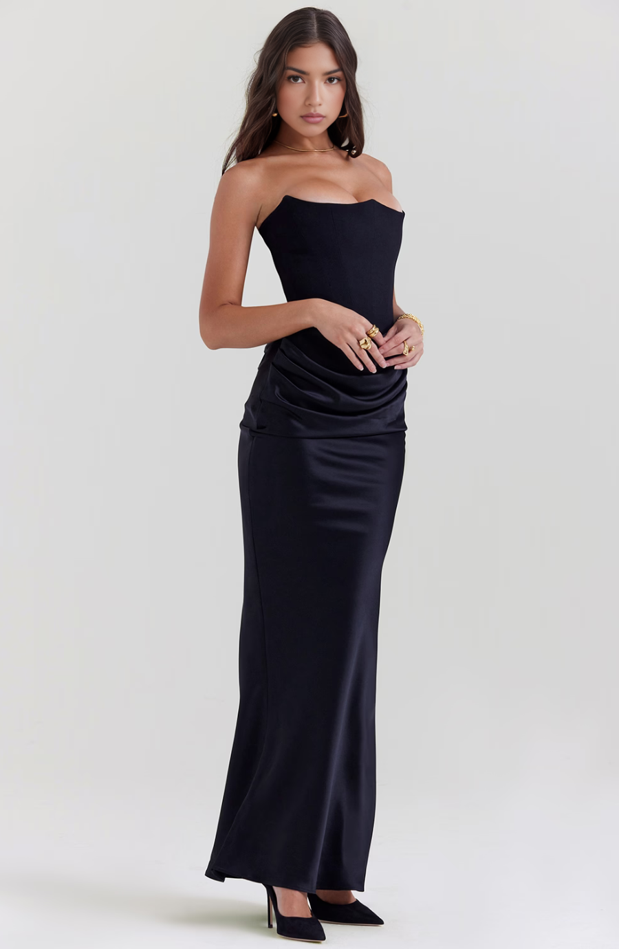 Woman wearing a strapless black evening gown on a white background
