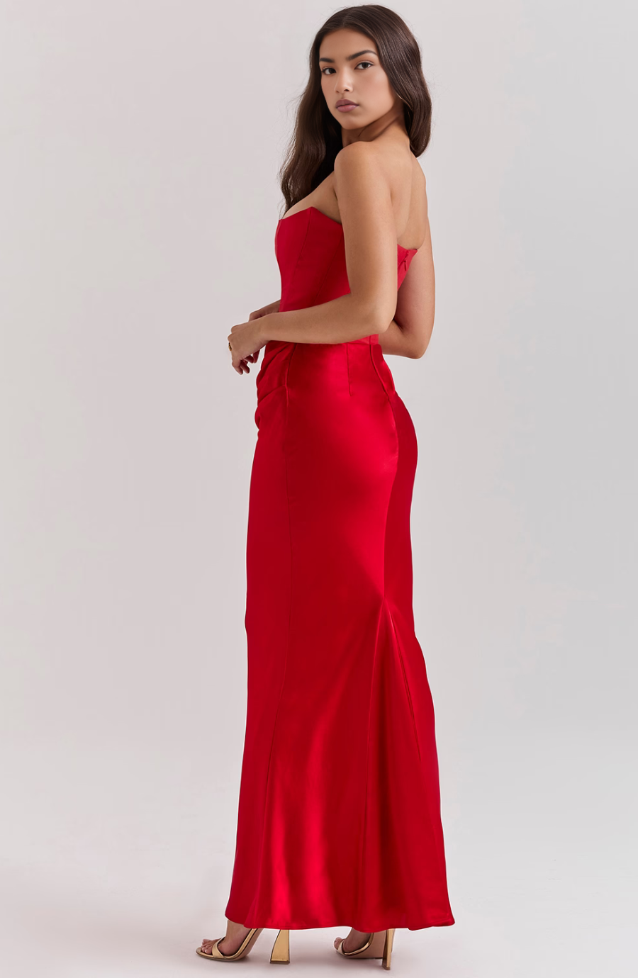 Woman wearing a red strapless gown on a white background