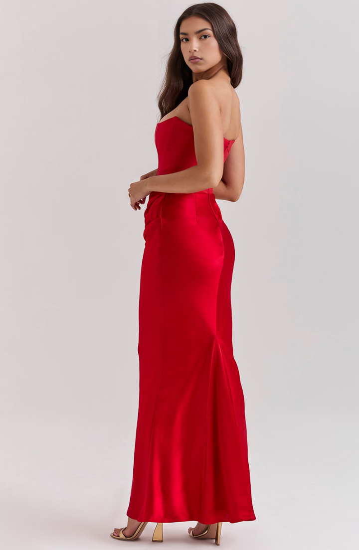Woman wearing a red strapless gown on a white background
