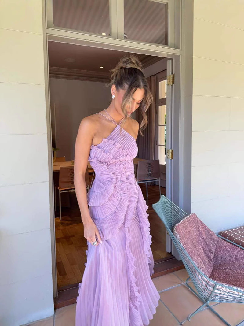 Woman in a lavender one-shoulder dress standing in a doorway.