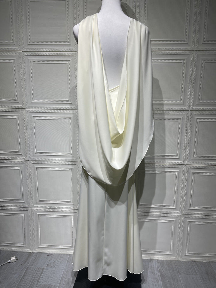 White dress on a mannequin against a gray paneled wall