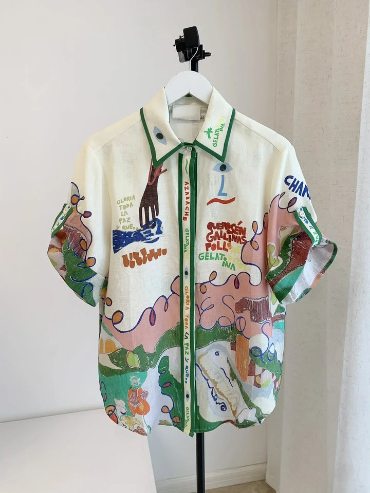 Colorful jacket with graphic designs on a hanger against a white wall
