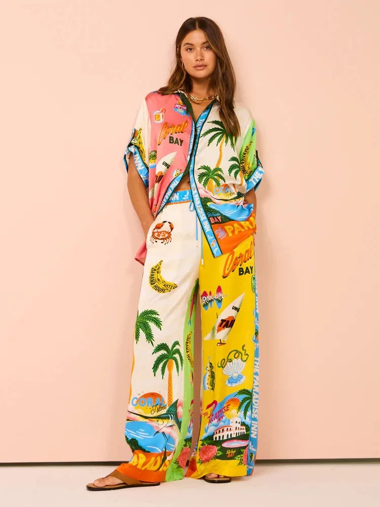 Woman wearing a colorful tropical-themed outfit with a pink bag on a light pink background