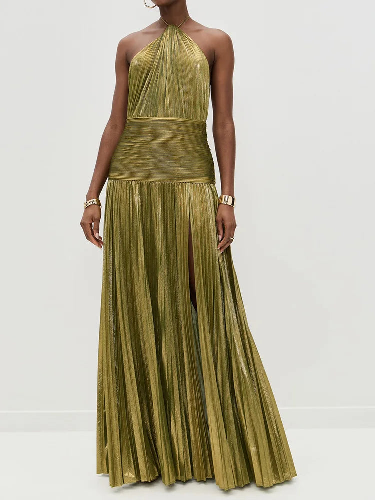 Woman wearing a gold pleated dress against a white background
