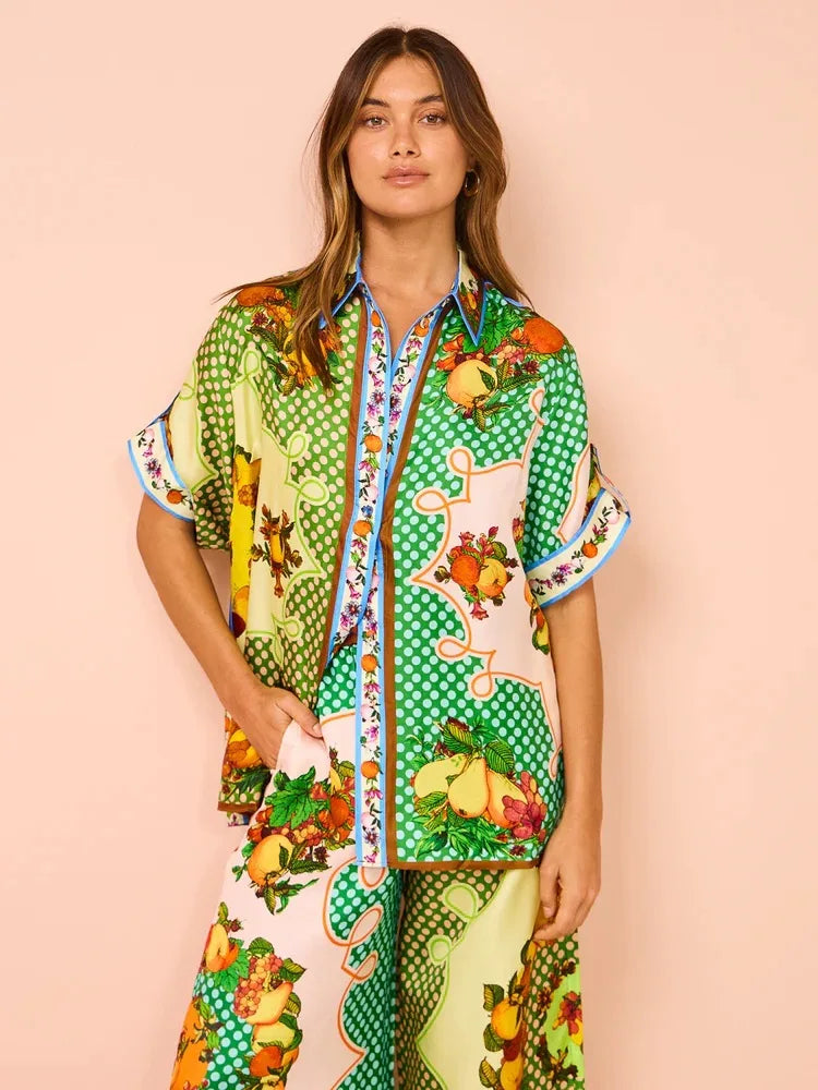 Woman wearing a colorful patterned outfit on a pink background