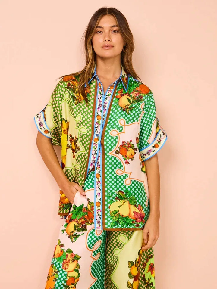 Woman wearing a colorful patterned outfit on a pink background