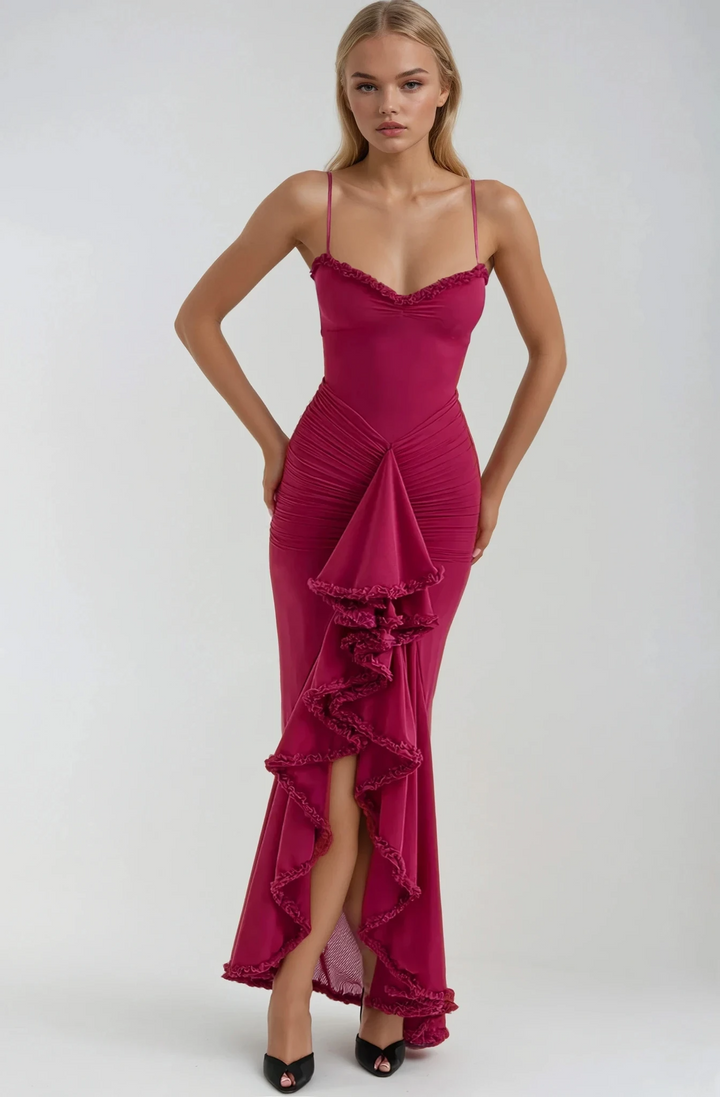 Woman wearing a pink evening gown with ruffled details on a white background