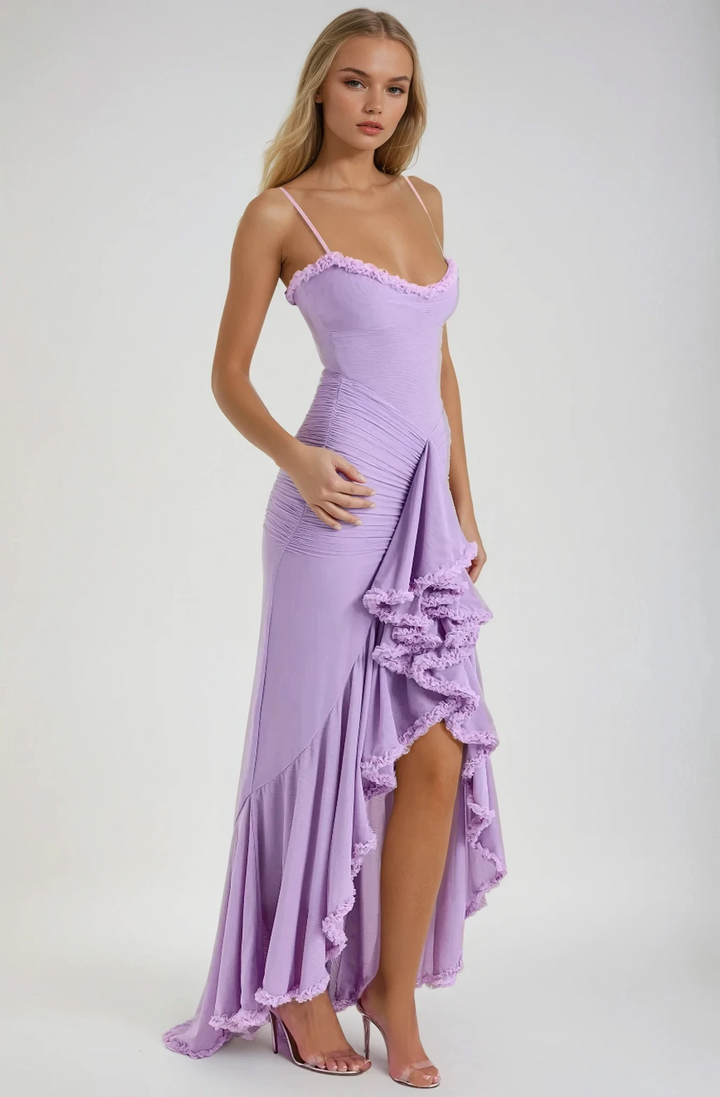 Woman wearing a purple dress with ruffled details on a white background