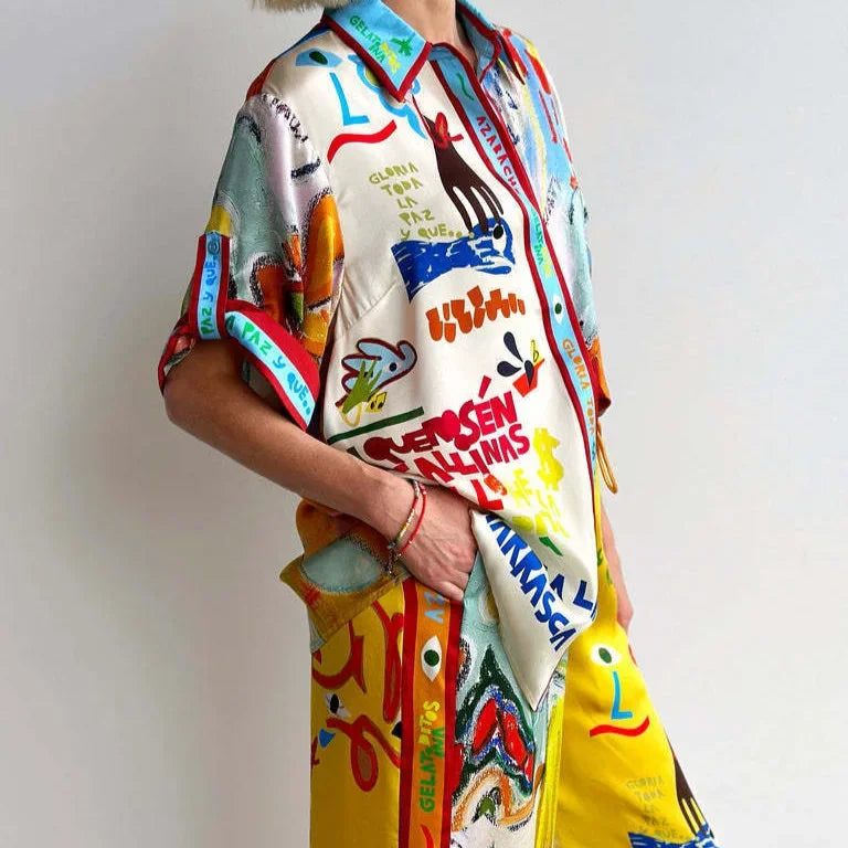 Person wearing a colorful, patterned shirt with abstract designs and text.