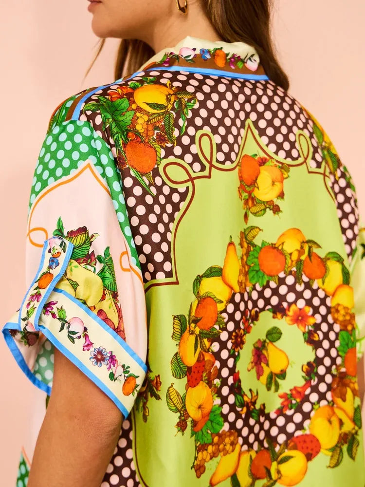 Colorful patterned shirt with fruit design on a plain background