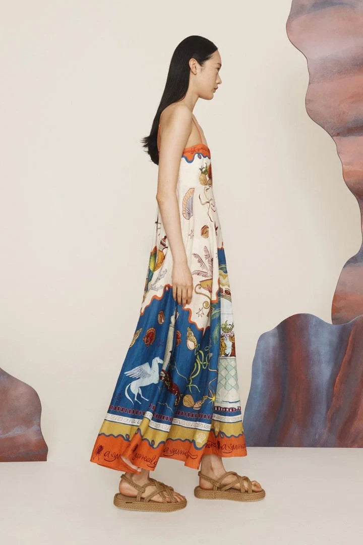Woman wearing a patterned dress standing against a neutral background