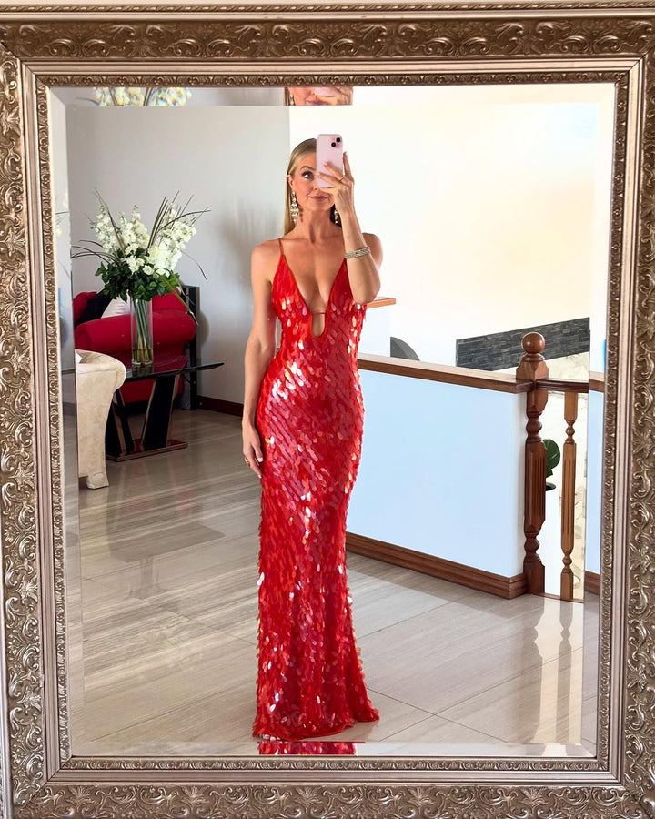 Person wearing a red sequin dress taking a mirror selfie.