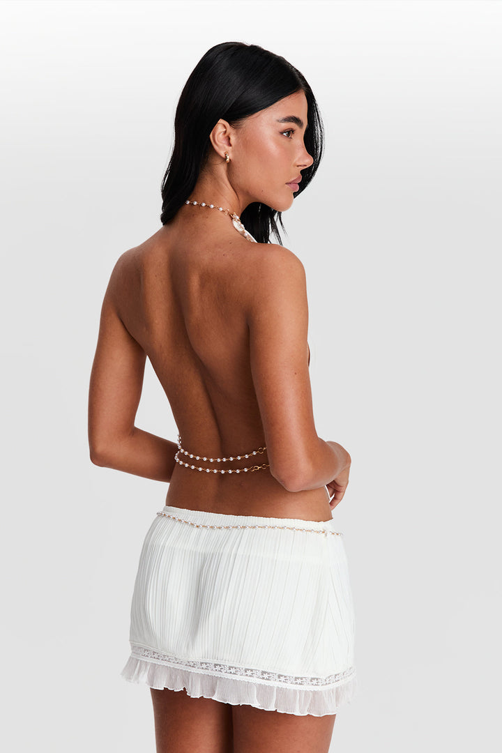 Woman wearing a white lace skirt with a plain background