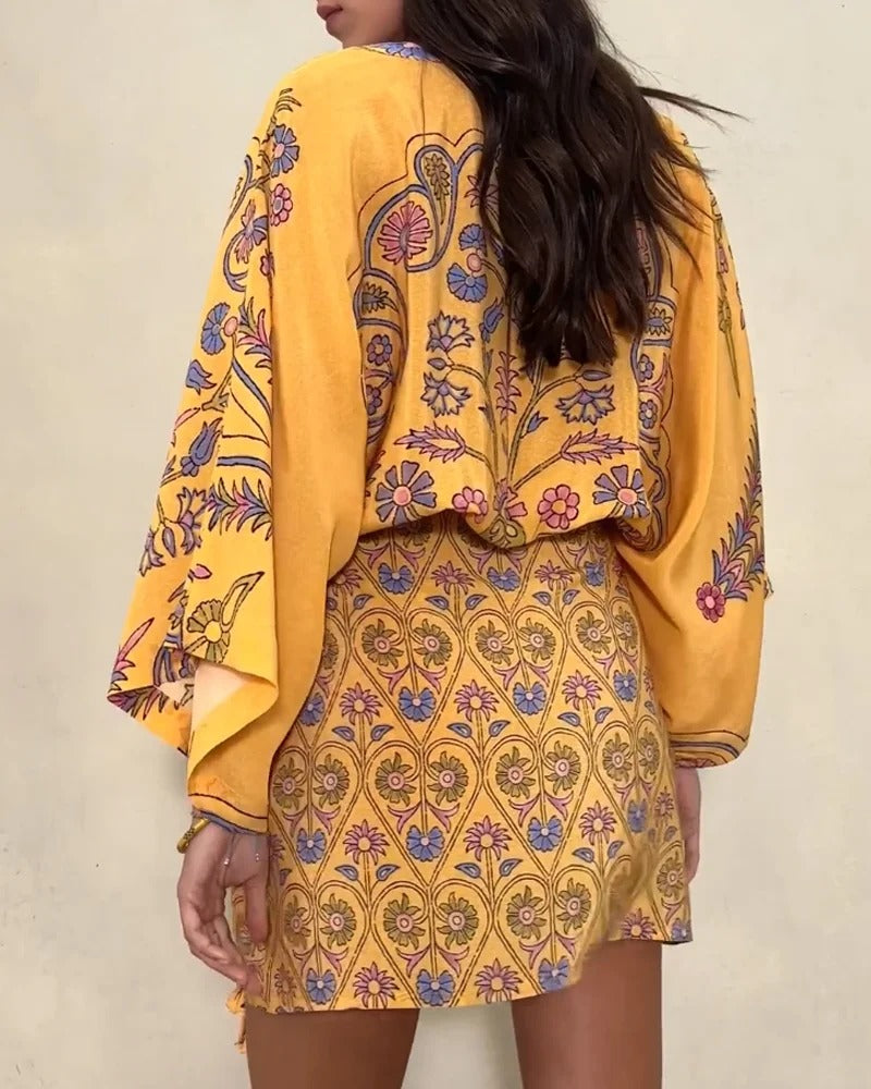 Person wearing a yellow outfit with intricate patterns on a plain background