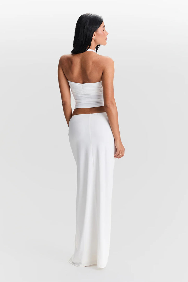 Woman wearing a white strapless dress with a brown belt on a white background
