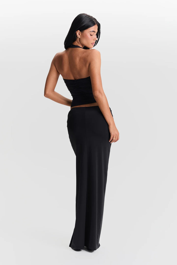 Woman wearing a black strapless top and high-waisted pants on a white background