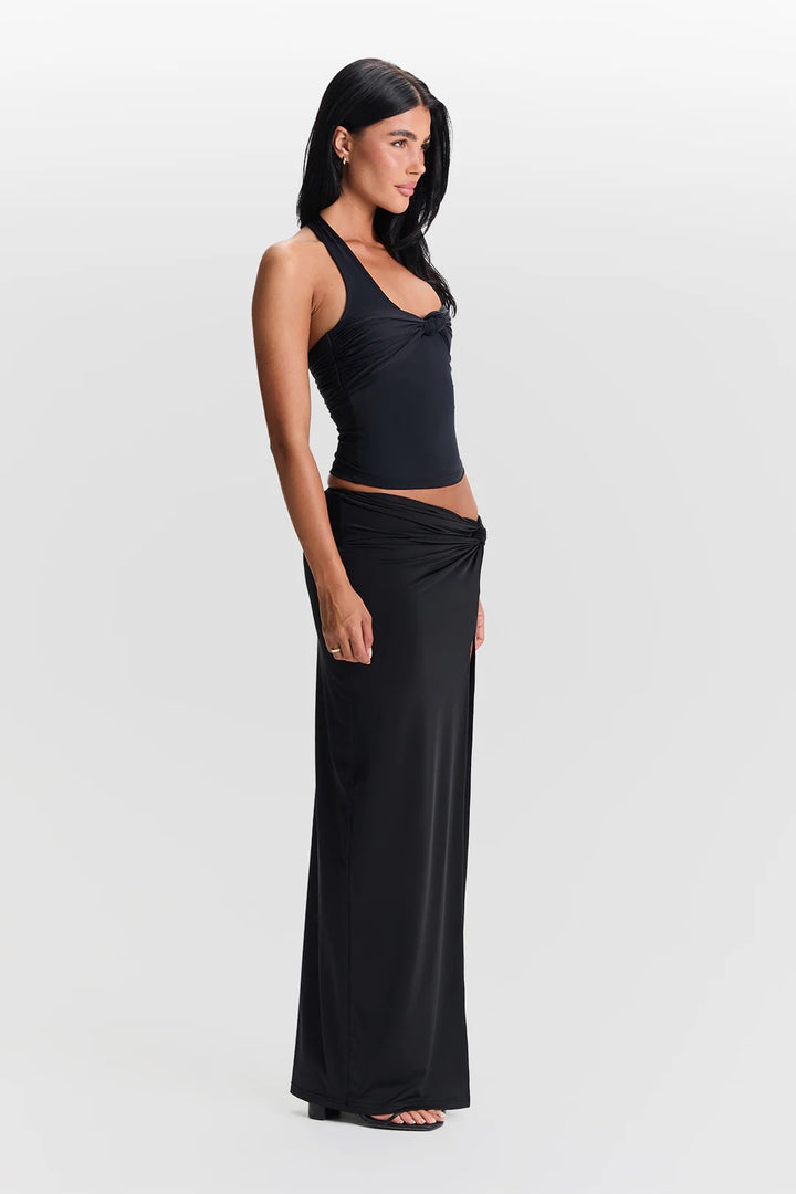 Woman wearing a black halter top and long black skirt on a white background