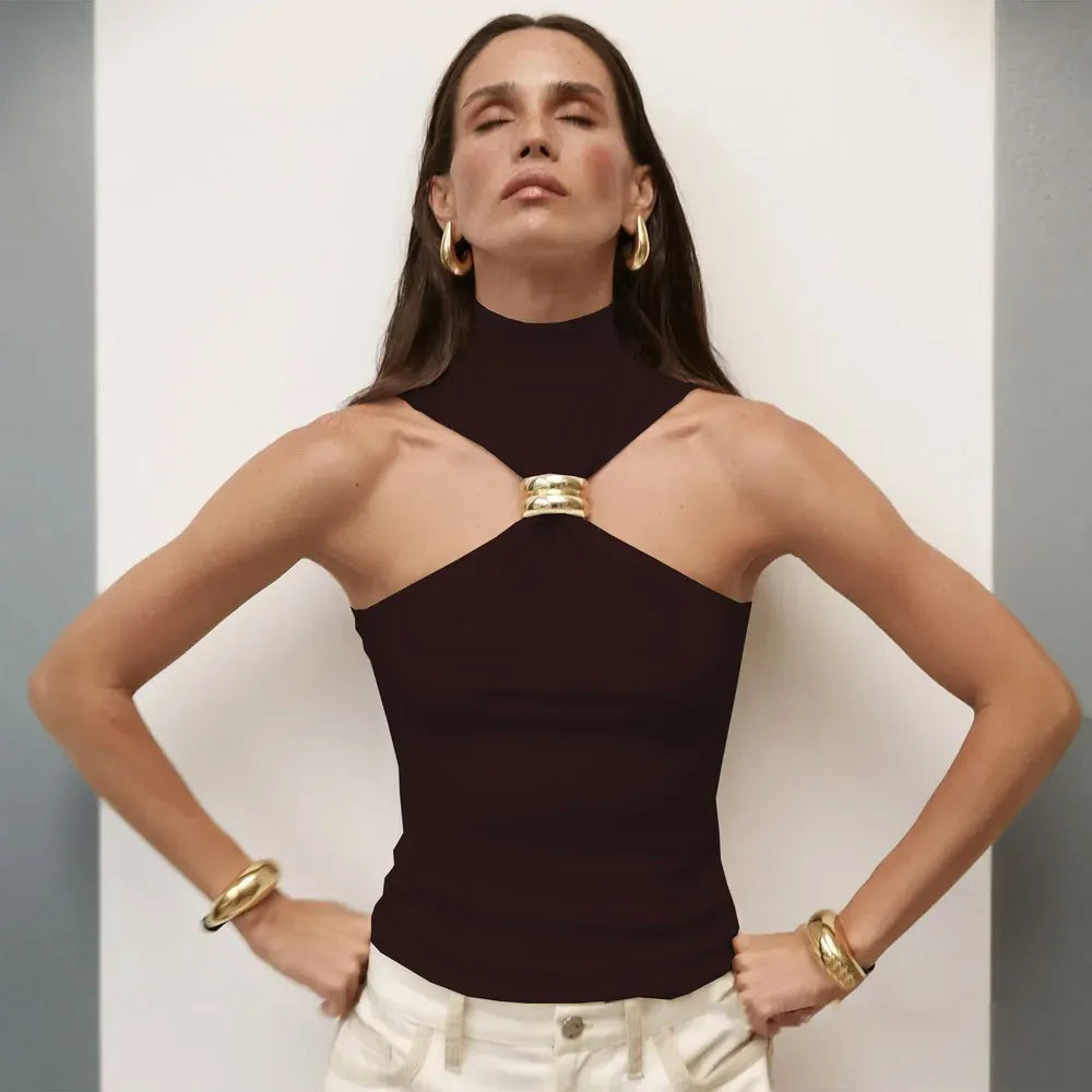 Woman wearing a dark brown halter top with gold accents against a neutral background