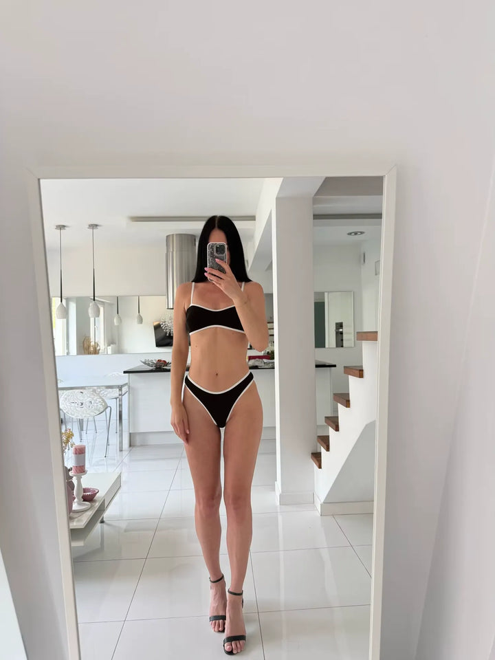 Person wearing a black bikini in a modern home setting