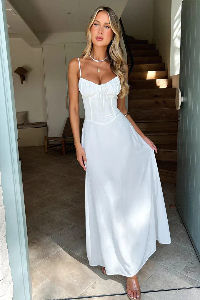 Woman in a white dress standing in a home setting