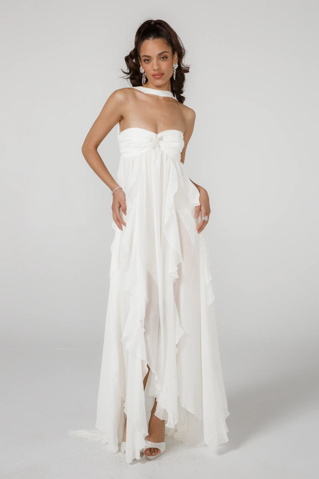 Woman wearing a white one-shoulder dress on a plain background